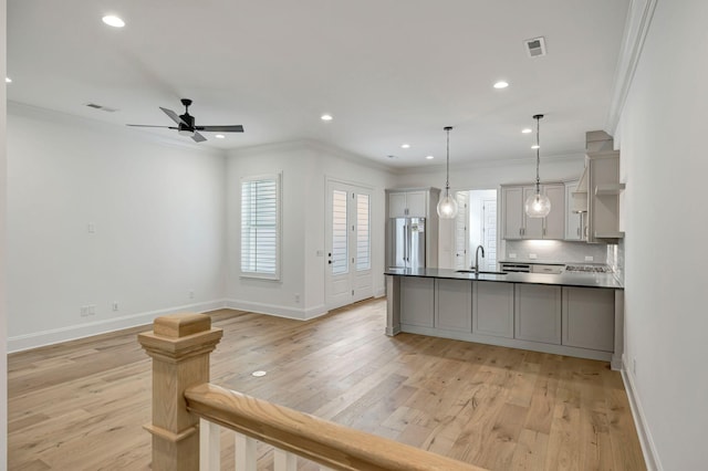 kitchen with crown molding, light hardwood / wood-style flooring, stainless steel fridge, gray cabinets, and pendant lighting