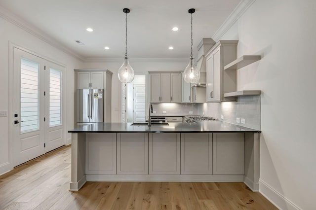 kitchen with gray cabinets, pendant lighting, stainless steel fridge, kitchen peninsula, and light wood-type flooring