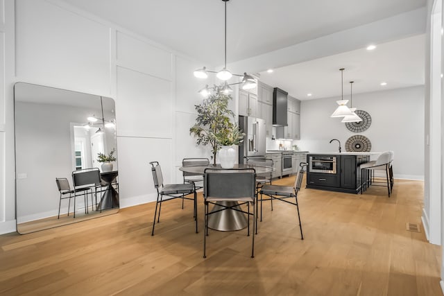 dining area featuring sink and light wood-type flooring