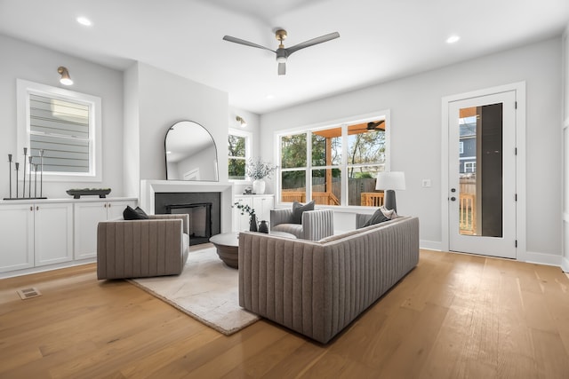 living room featuring light hardwood / wood-style floors and ceiling fan