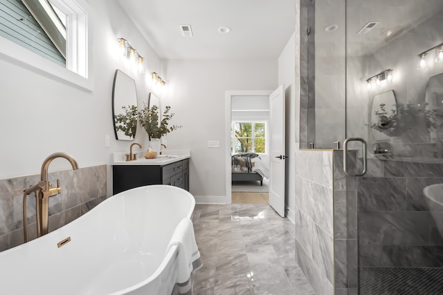 bathroom with vanity and separate shower and tub