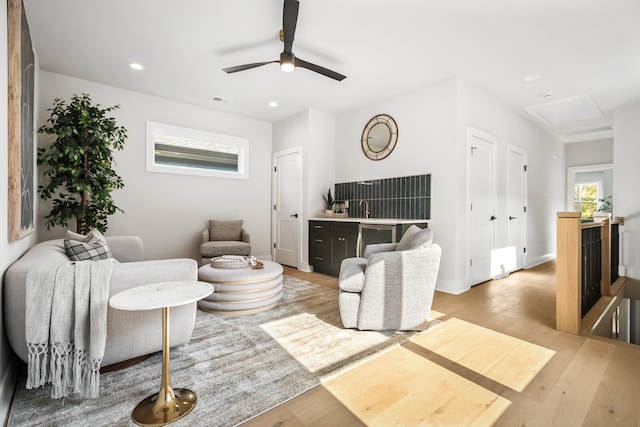 living room featuring light hardwood / wood-style floors and ceiling fan