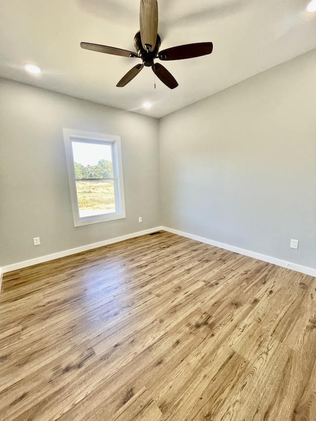 spare room with ceiling fan and light wood-type flooring