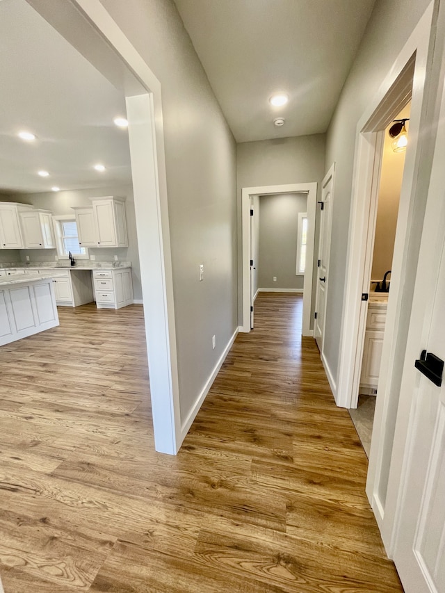 hall featuring sink and light wood-type flooring