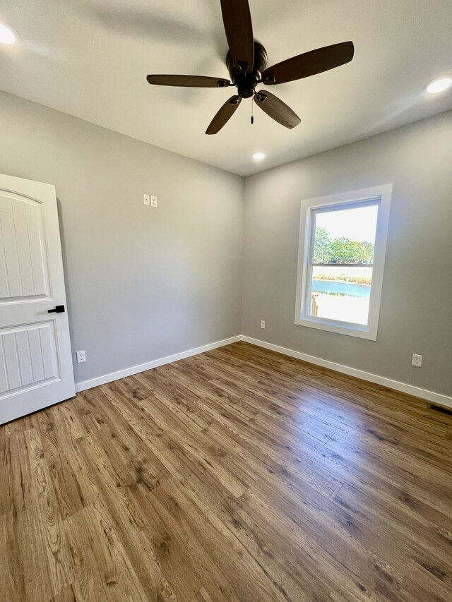 spare room featuring wood-type flooring and ceiling fan