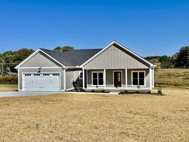 view of front of house featuring covered porch, a front lawn, and a garage