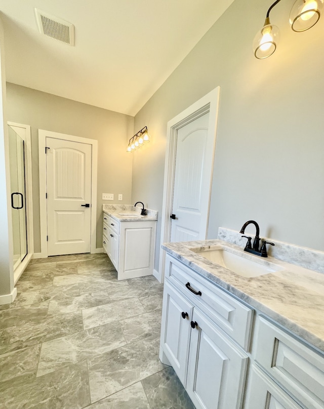 bathroom with vanity and a shower with door