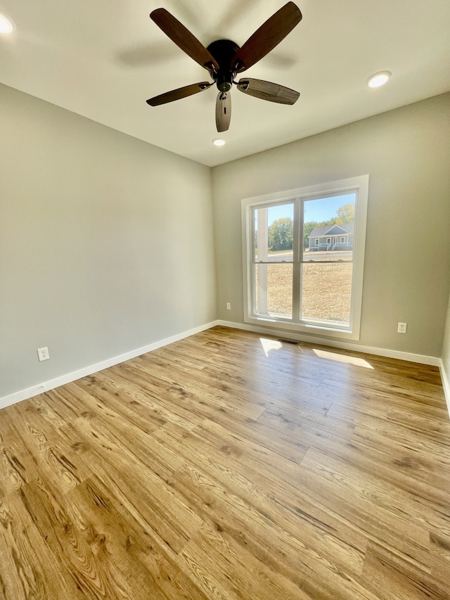 spare room with light hardwood / wood-style flooring and ceiling fan