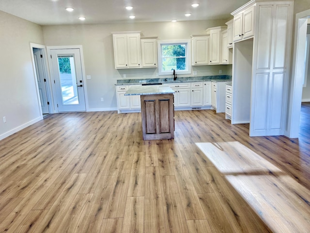 kitchen featuring white cabinetry, a center island, a wealth of natural light, and light wood-type flooring