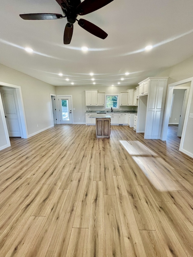 unfurnished living room featuring light hardwood / wood-style flooring and ceiling fan