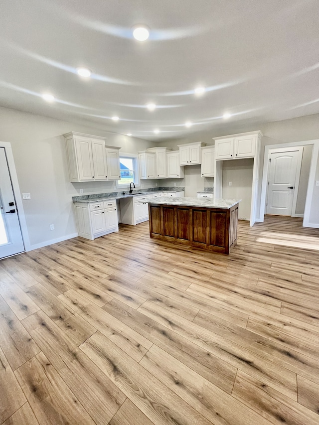 kitchen featuring a kitchen island, white cabinetry, and light hardwood / wood-style floors