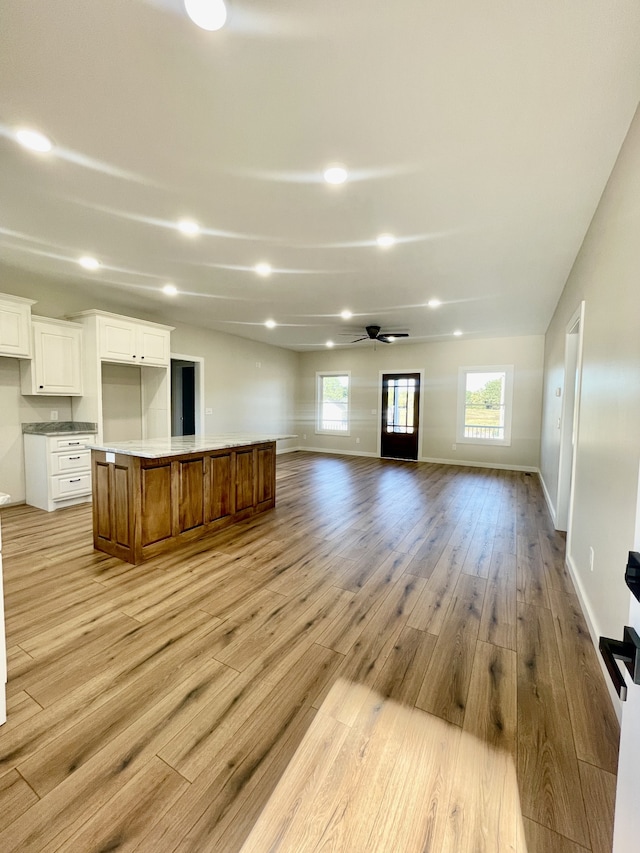 unfurnished living room with light hardwood / wood-style flooring and ceiling fan