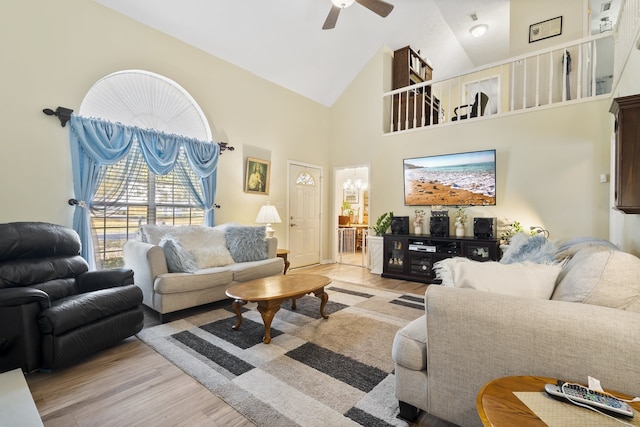 living room with ceiling fan, high vaulted ceiling, and light hardwood / wood-style floors