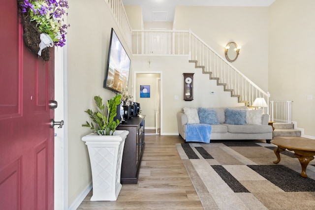 foyer featuring a towering ceiling and light hardwood / wood-style flooring