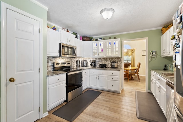 kitchen featuring light hardwood / wood-style flooring, white cabinets, stainless steel appliances, and ornamental molding