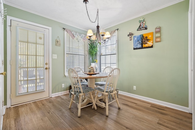 dining area with crown molding, hardwood / wood-style floors, and an inviting chandelier