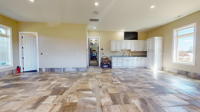 unfurnished living room featuring sink and plenty of natural light