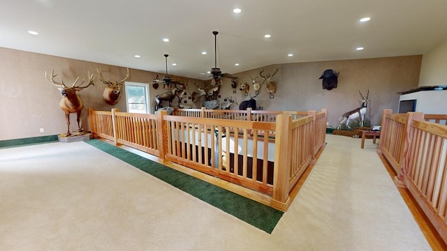 interior space with light carpet, pendant lighting, and ceiling fan