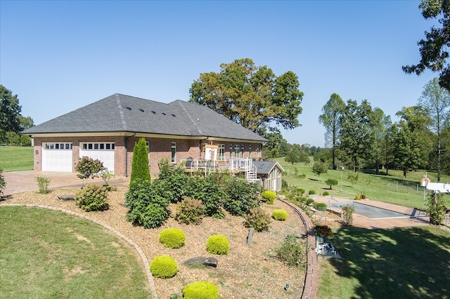 exterior space featuring a garage, a deck, and a lawn