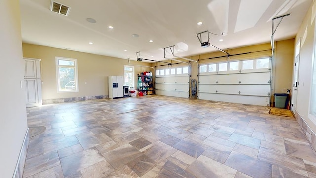 garage with white fridge with ice dispenser and a garage door opener