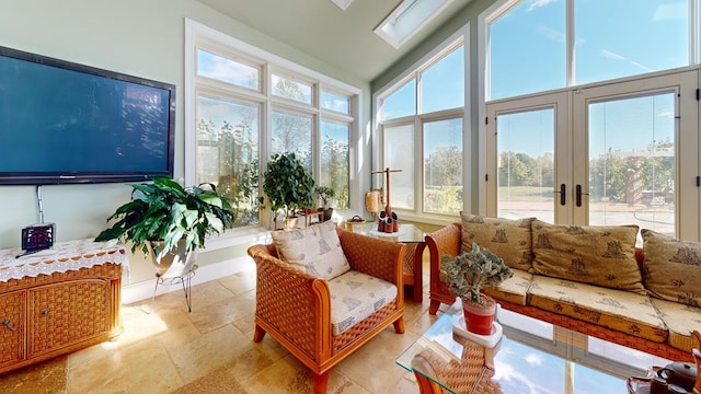 sunroom / solarium featuring lofted ceiling with skylight and french doors