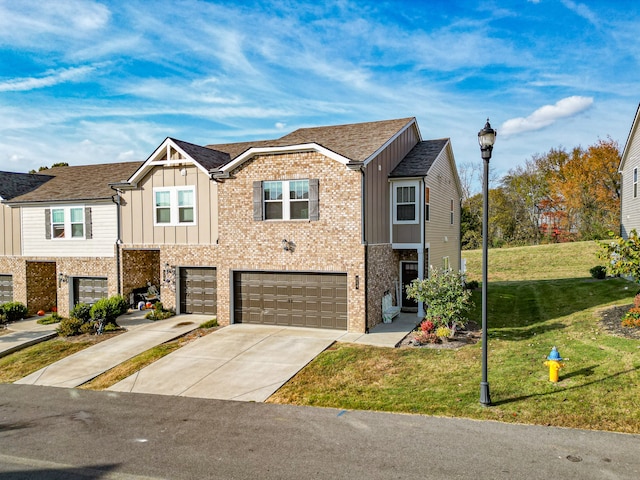 multi unit property featuring a front lawn and a garage