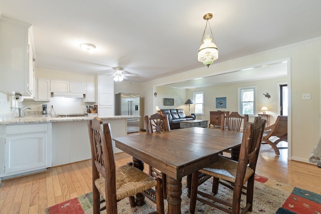 dining area featuring sink, ceiling fan, crown molding, and light hardwood / wood-style floors