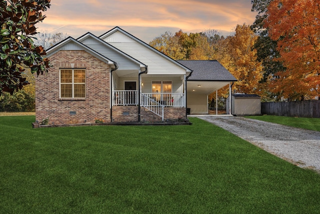 view of front of house featuring a storage shed, a yard, a carport, and a porch