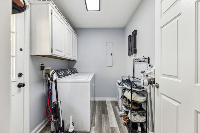 laundry area featuring electric panel, washing machine and clothes dryer, dark hardwood / wood-style floors, and cabinets