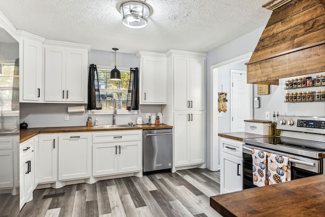 kitchen featuring appliances with stainless steel finishes, sink, wooden counters, white cabinets, and dark hardwood / wood-style floors