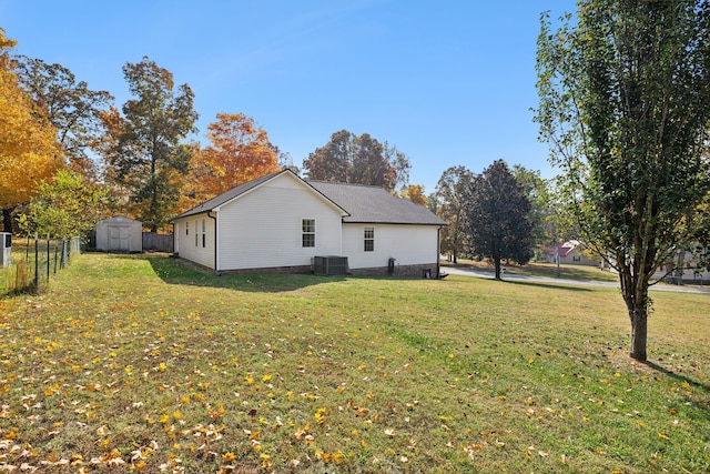 view of property exterior featuring a storage shed, central air condition unit, and a lawn