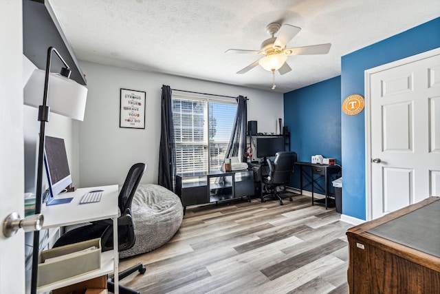 home office featuring ceiling fan, a textured ceiling, and light wood-type flooring