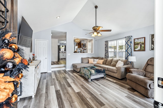 living room featuring hardwood / wood-style floors, ceiling fan, and vaulted ceiling