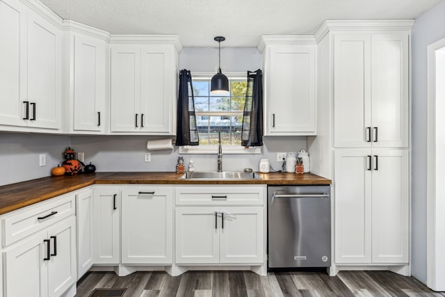 kitchen with sink, dishwasher, butcher block counters, and white cabinets