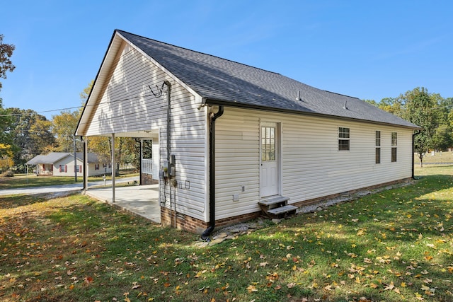 view of side of property with a patio and a lawn