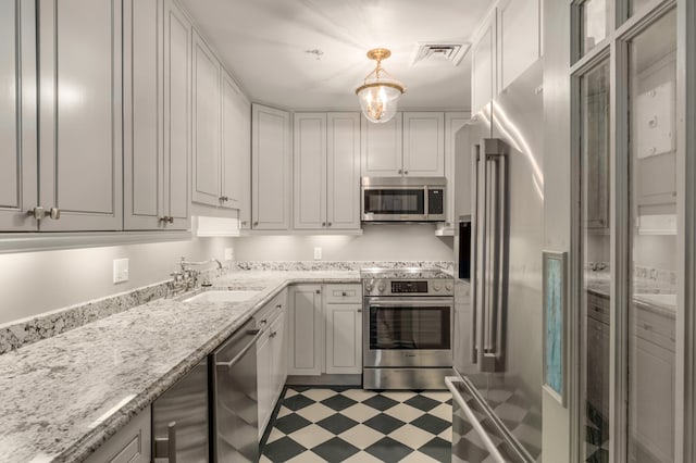 kitchen featuring appliances with stainless steel finishes, decorative light fixtures, sink, and white cabinetry