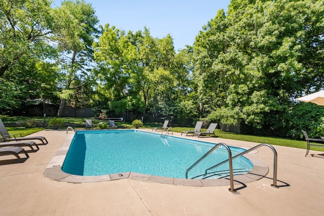 view of swimming pool featuring a yard and a patio