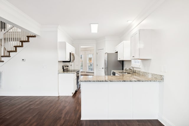 kitchen with light stone countertops, dark wood-type flooring, kitchen peninsula, white cabinets, and appliances with stainless steel finishes