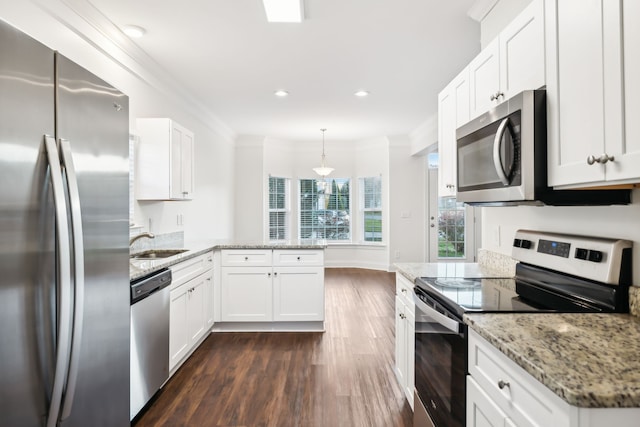 kitchen with appliances with stainless steel finishes, dark wood-type flooring, white cabinetry, and pendant lighting