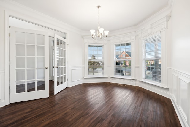 unfurnished dining area with a chandelier, french doors, hardwood / wood-style flooring, and ornamental molding