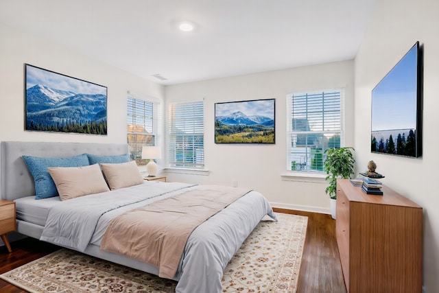 bedroom featuring dark hardwood / wood-style floors and multiple windows