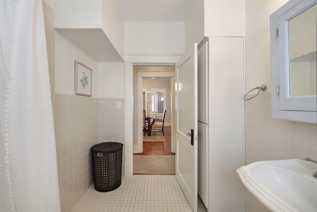 bathroom with tile walls, sink, and tile patterned flooring