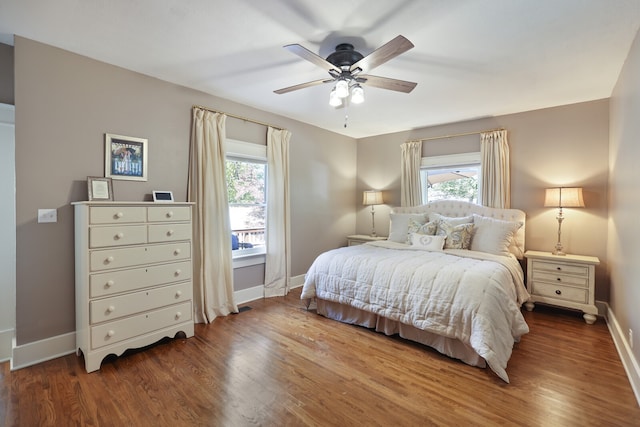 bedroom with multiple windows, dark hardwood / wood-style floors, and ceiling fan