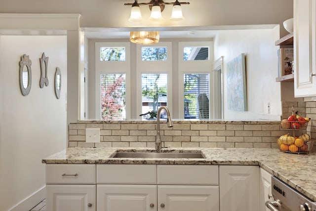 kitchen with sink, white cabinetry, light stone counters, and backsplash