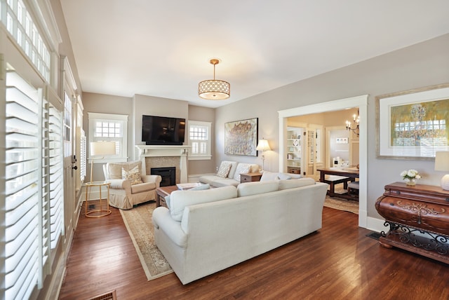 living room featuring a chandelier, plenty of natural light, and dark hardwood / wood-style floors