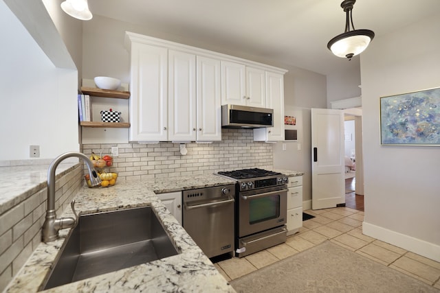 kitchen with sink, white cabinets, decorative light fixtures, and stainless steel appliances