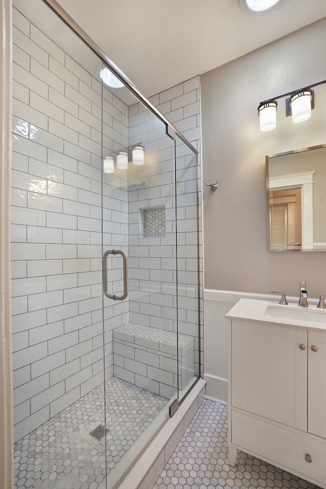 bathroom featuring vanity, tile patterned floors, and a shower with door