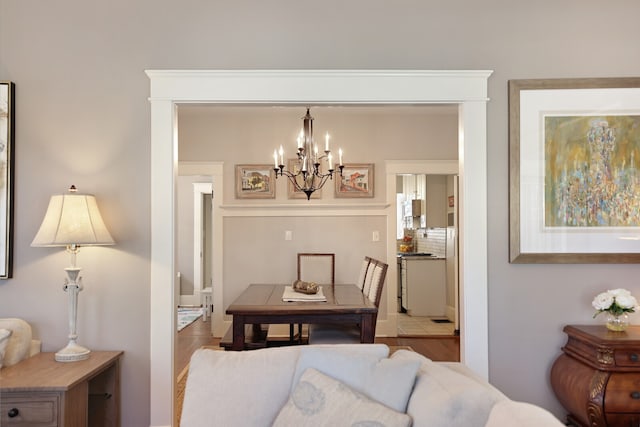 dining space with hardwood / wood-style flooring and an inviting chandelier