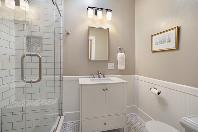 bathroom with vanity, a shower with shower door, toilet, and tile patterned floors