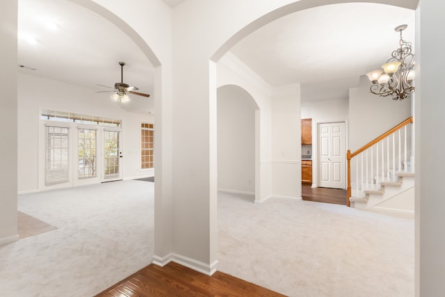 hall with carpet floors and an inviting chandelier